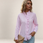 Valvet Oak House light pink striped button-down shirt with ruffled trim worn by a woman with jeans and a clutch bag