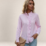 Valvet Oak House light pink striped button-down shirt with ruffled trim worn by a woman with jeans and a clutch bag