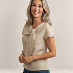 Valvet Oak House beige linen short-sleeve blouse with a draped neck detail worn by a smiling woman