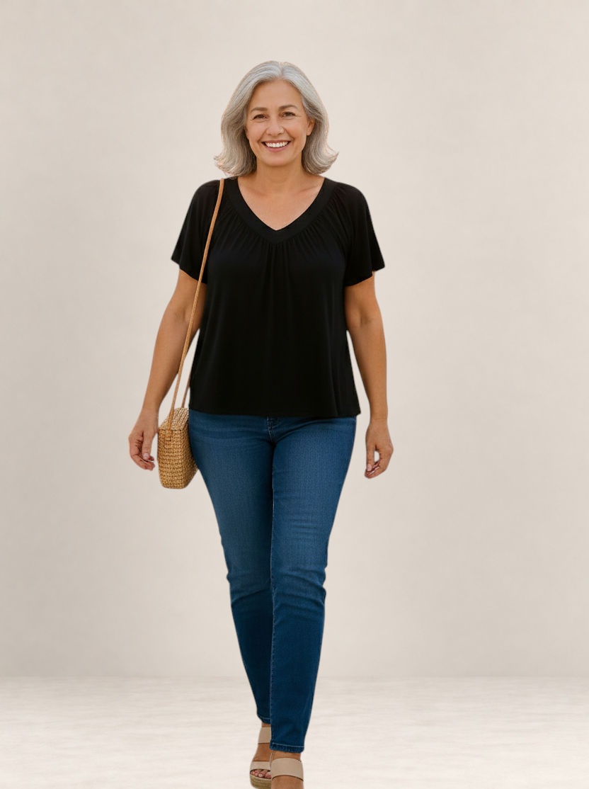 Valvet Oak House Despina black V-neck blouse with a loose, flattering fit worn by a smiling woman with grey hair.