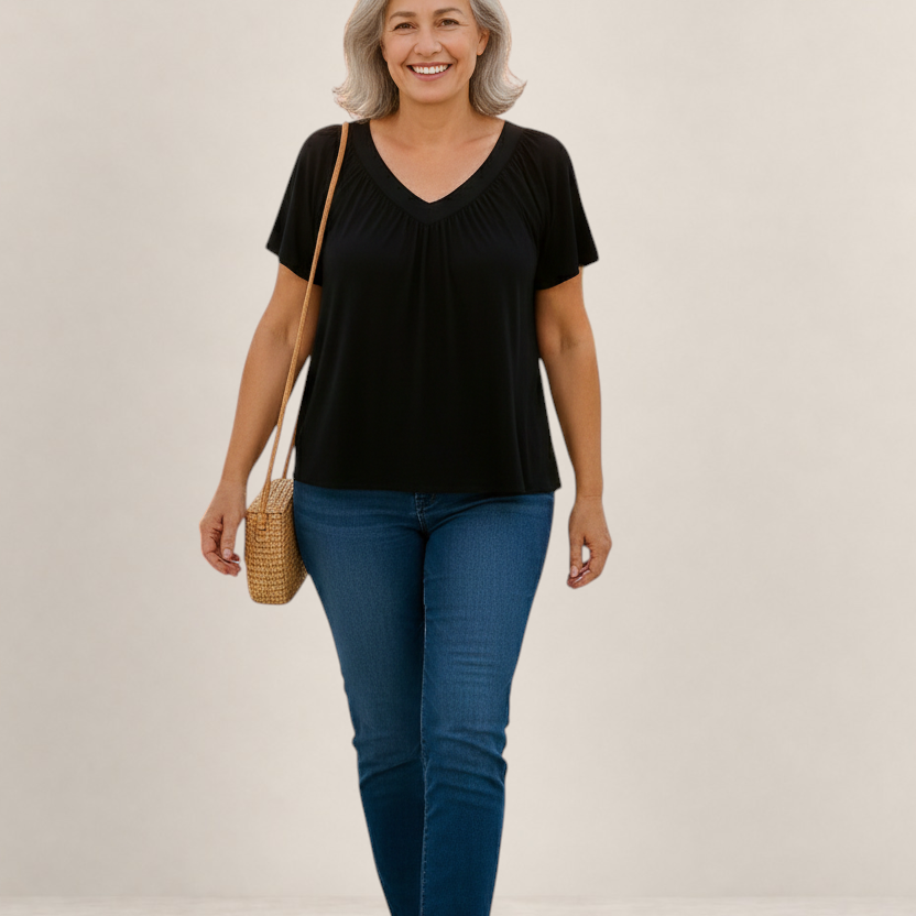 Valvet Oak House Despina black V-neck blouse with a loose, flattering fit worn by a smiling woman with grey hair.