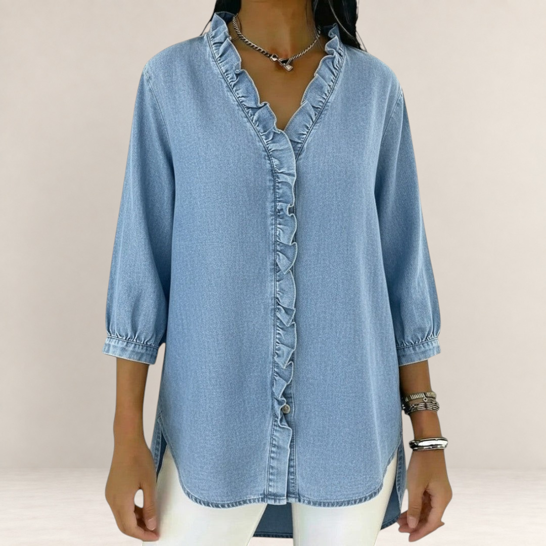 Valvet Oak House Elena light blue denim blouse with ruffled trim, V-neck, and three-quarter sleeves.