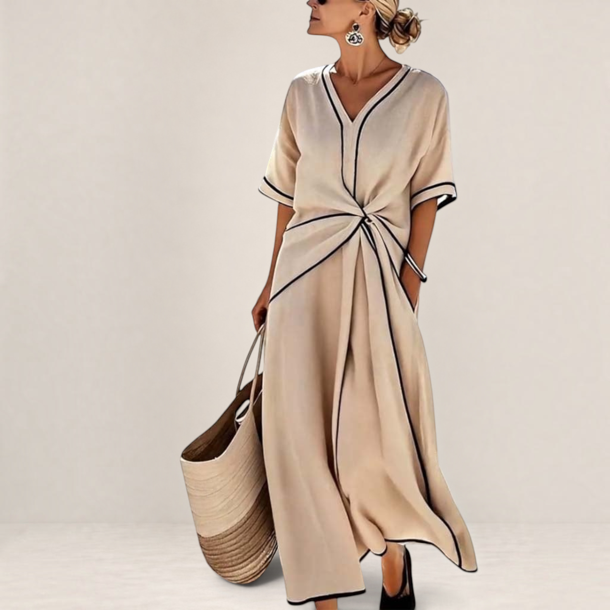 Valvet Oak House Mila beige midi dress with V-neck, contrast piping, and waist detail, worn by a woman by the sea.