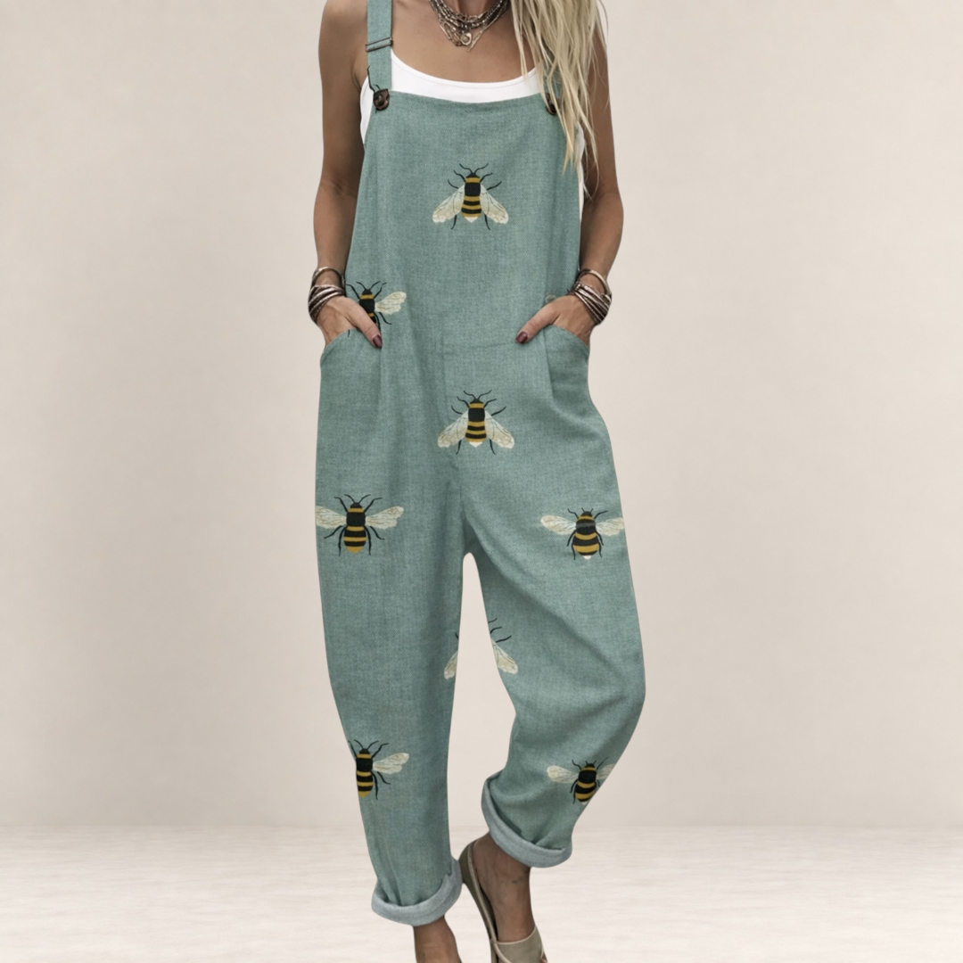 Valvet Oak House sage green printed jumpsuit with bee pattern, featuring wide legs, pockets, and adjustable straps.