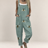 Valvet Oak House sage green printed jumpsuit with bee pattern, featuring wide legs, pockets, and adjustable straps.