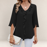 Valvet Oak House black blouse with ruffled neckline and 3/4 sleeves worn with white trousers and a clutch bag