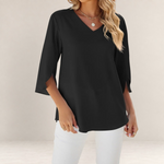 Valvet Oak House black blouse with V-neck and 3/4 flared sleeves worn with white trousers