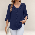 Valvet Oak House navy blue blouse with V-neck, front ruffles, and 3/4 slit sleeves worn with white trousers