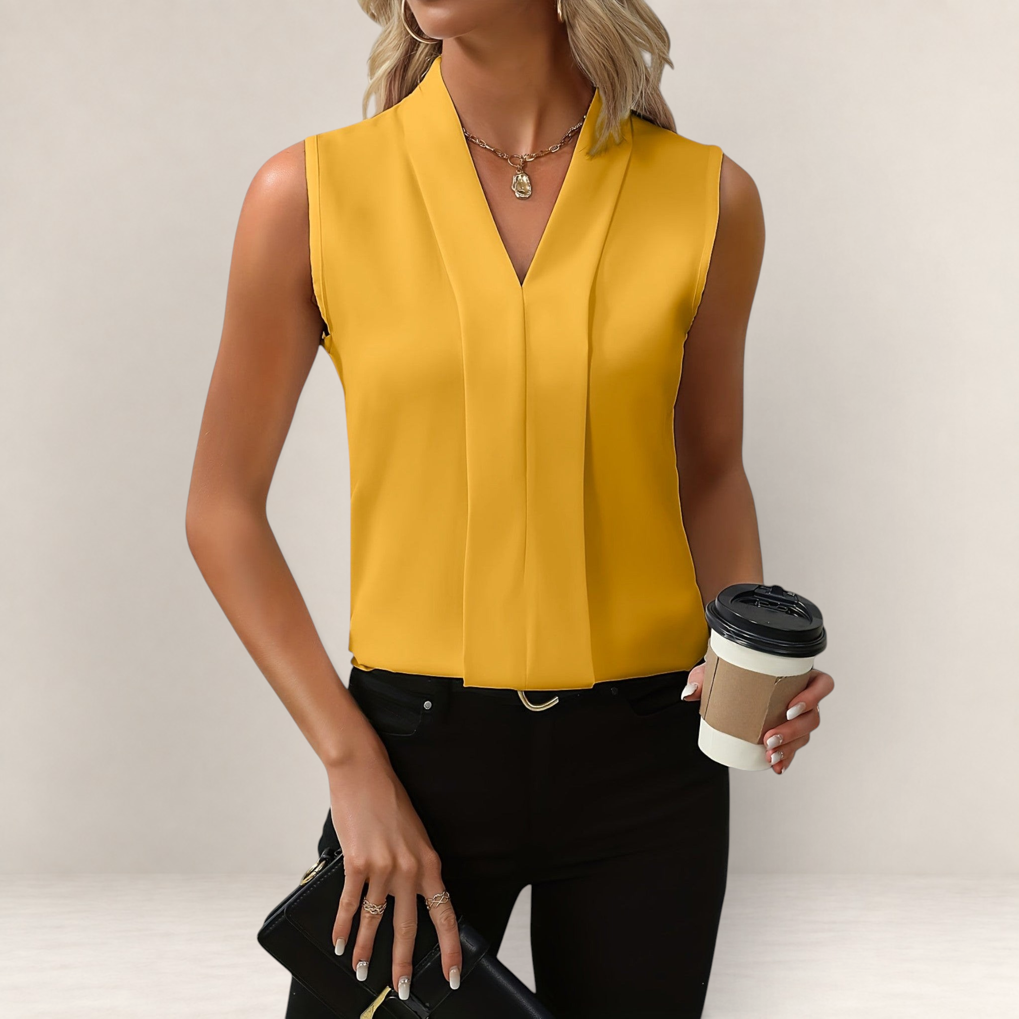 Valvet Oak House sleeveless mustard yellow blouse with a deep V-neckline and relaxed fit worn with black trousers.