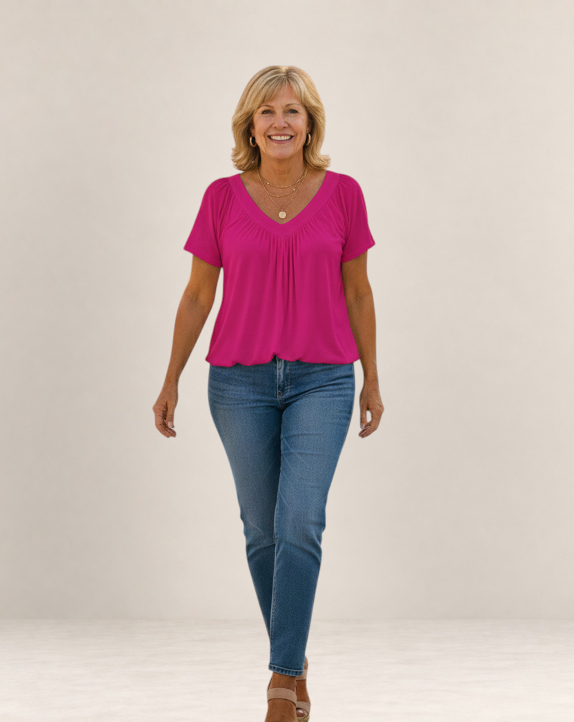 Valvet Oak House Despina fuchsia pink blouse with a flattering V-neck and loose fit worn by a smiling woman.
