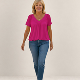 Valvet Oak House Despina fuchsia pink blouse with a flattering V-neck and loose fit worn by a smiling woman.