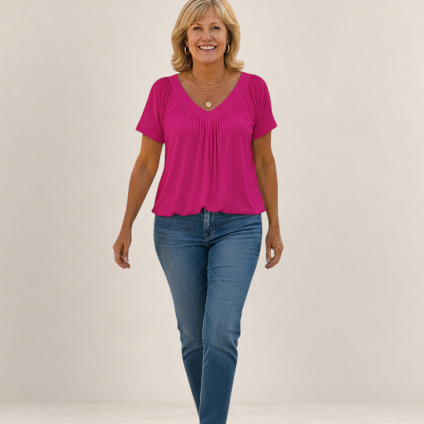 Valvet Oak House Despina fuchsia pink blouse with a flattering V-neck and loose fit worn by a smiling woman.