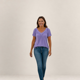 Valvet Oak House Despina lavender blouse with V-neck and pleated details worn by a smiling woman with blue jeans